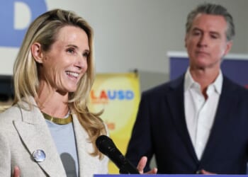 California Governor Gavin Newsom looks on as his wife Jennifer Siebel Newsom speaks at Belvedere Middle School in Los Angeles on Oct. 8, 2025.