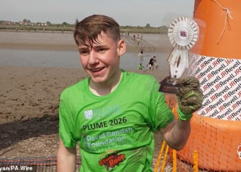 Albert Crates (pictured) managed to run, walk and crawl his way to victory on Sunday across a 440m stretch of the muddy River Blackwater in Essex - making him the youngest person to win the race