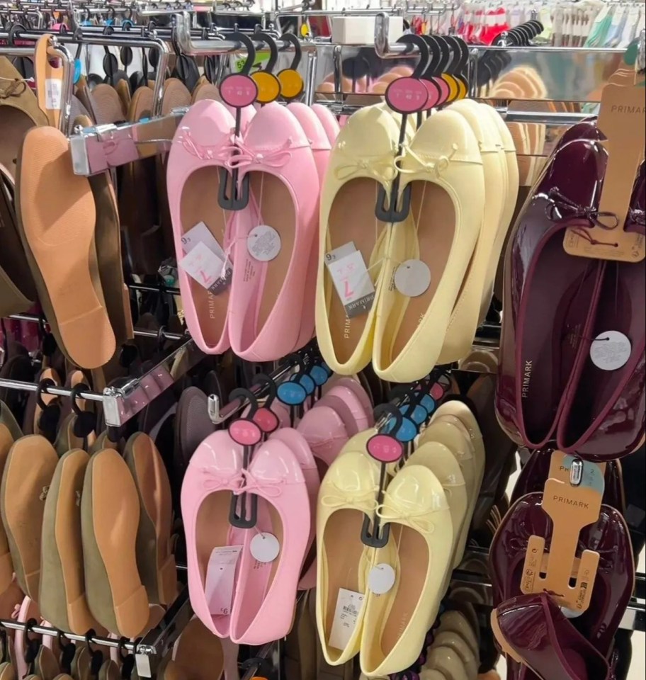 Rows of pink, yellow, and burgundy ballet flats with bows on display.