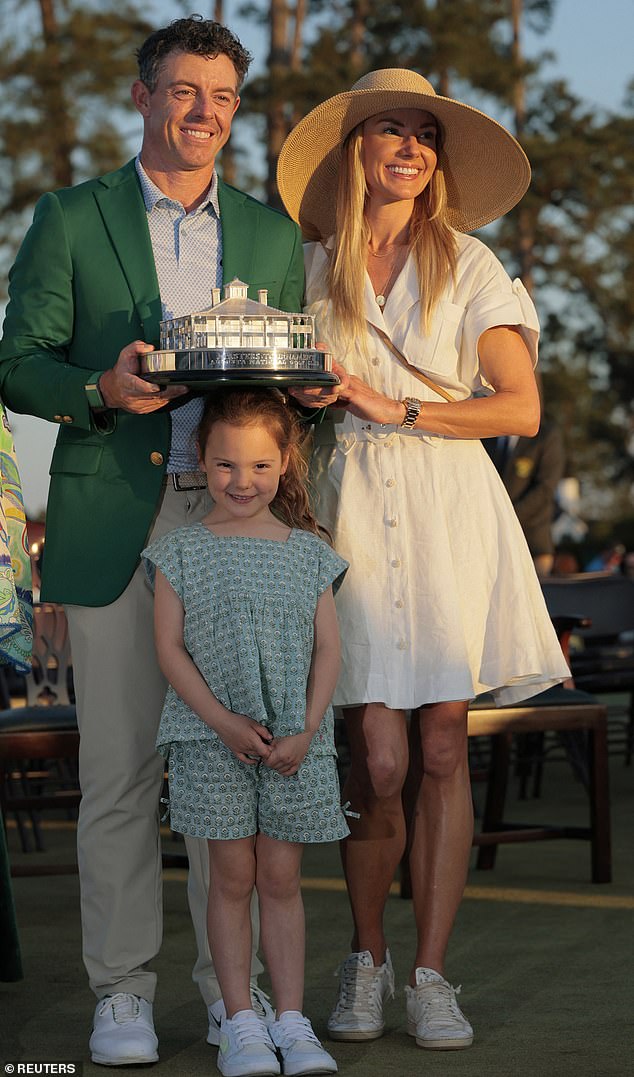 Rory, Erica and Poppy as he celebrates with his green jacket and the trophy after winning The Masters