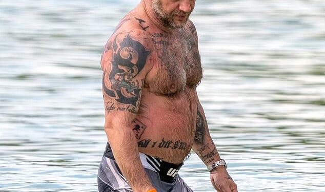 Tom Hardy showcased his array of body ink as he kicked back on the beach with his wife Charlotte Riley on a family holiday in Barbados on Wednesday