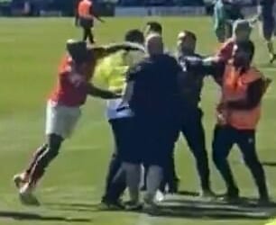 York City midfielder Hiram Boateng was seen striking out at a Rochdale fan amid a pitch invasion in an apparent retaliation after being pushed to the ground