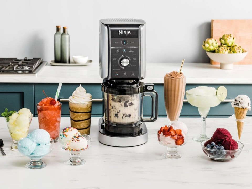 Ninja CREAMi Deluxe 10-in-1 Ice Cream and Frozen Drink Maker surrounded by various frozen treats.