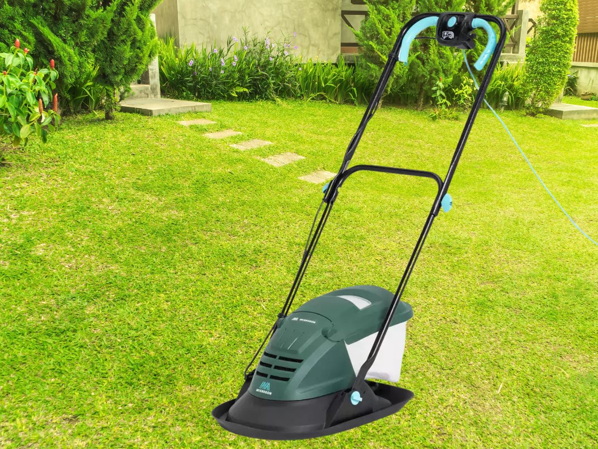 A green lawnmower with a teal handle and cord on a green lawn.