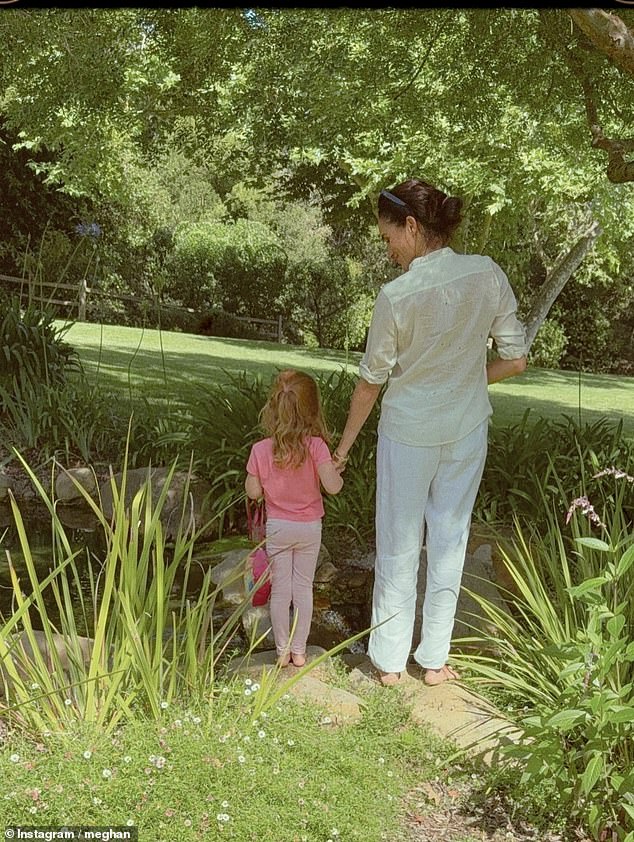 Meghan and Princess Lilibet, four, as seen in a photo posted by the Duchess on International Day of the Girl