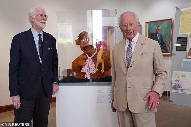 King Charles meets Bermuda-born Michael Frith, designer of the Muppets, as the pair pose next to a puppet of Fozzie Bear from the iconic children's series