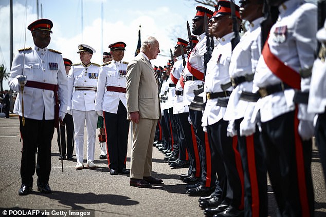 King Charles III greets members of the Royal Bermuda Regiment during a ceremonial welcome