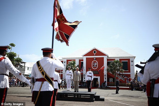 King Charles III reviews the troops during a ceremonial welcome at King's Square in St George