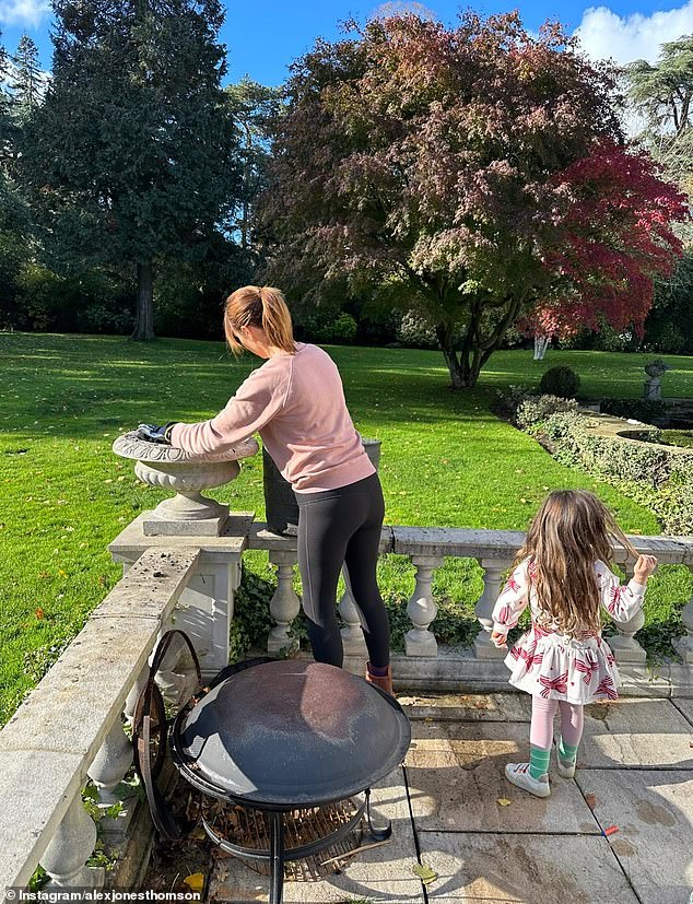 She's already noticed the benefits of the cleaner air, revealing her kids - Teddy, nine, Kit, six, and Annie, four - have stopped coughing. Pictured: Alex with Annie at their new home