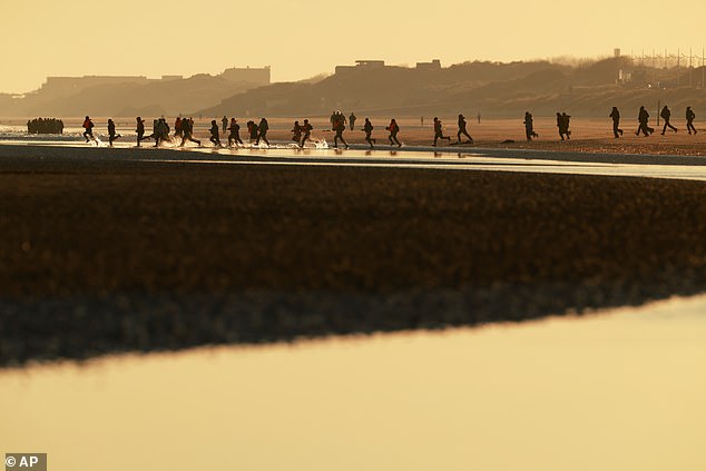 Migrants dash to board a small boat in an attempt to reach Britain in northern France. Gangs trying to evade increased police patrols on French beaches by launching ¿taxi boats¿ from West Flanders, south-west of Bruges