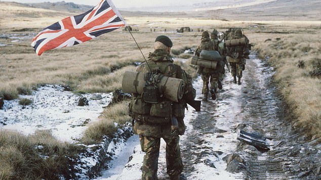 Royal Marine Peter Robinson carrying the Union Jack as he marched towards Stanley in the final hours of the Falklands War in June 1982