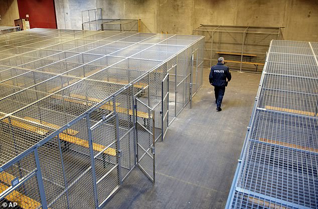 A Danish police officer walks through a temporary immigration detention centre in the country