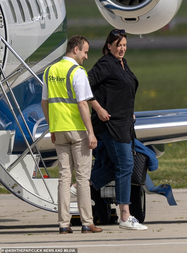 Keeping comfortable in a pair of white trainers, the TV star toted a large black handbag and placed a pair of sunglasses on her head