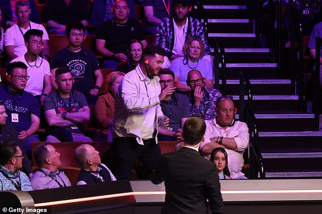 A spectator, pictured standing up, had also been thrown out for a bizarre shout about the Epstein Files during a semi-final at the venue on Saturday