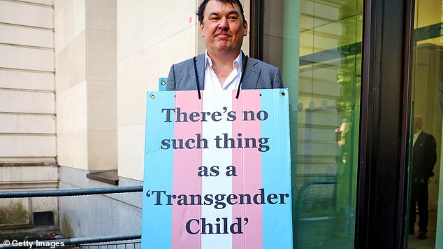 Graham Linehan poses with a placard reading "There's no such thing as a transgender child" outside Westminster Magistrates Court on September 4 2025