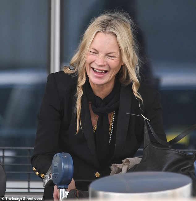 The supermodel, 52, had the giggles as she collected her luggage and headed outside of the airport to light a cigarette