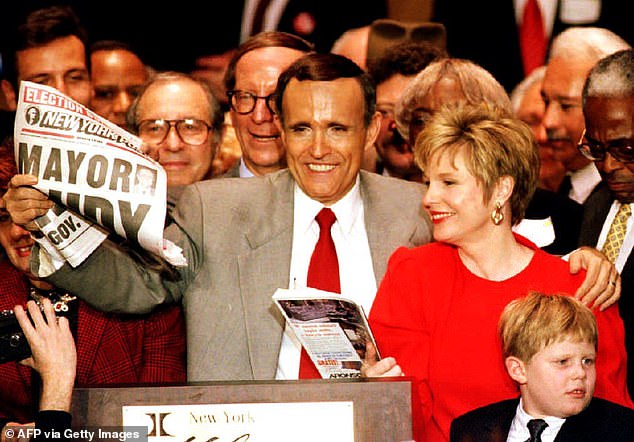 Giuliani holding up a paper touting his mayoral victory in November 1993