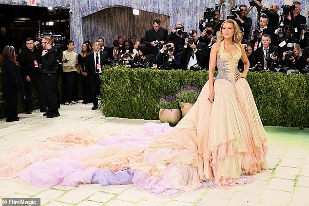 Leaning into full red carpet theatrics, the look was finished with a sweeping 13-foot train that trailed behind her