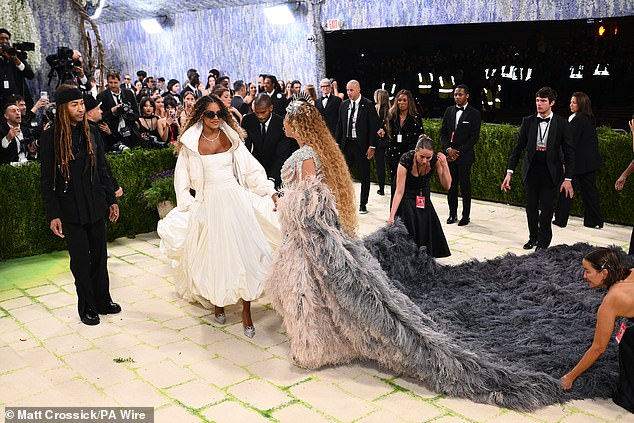 Beyonce's elaborate feathered train required multiple hands for assistance