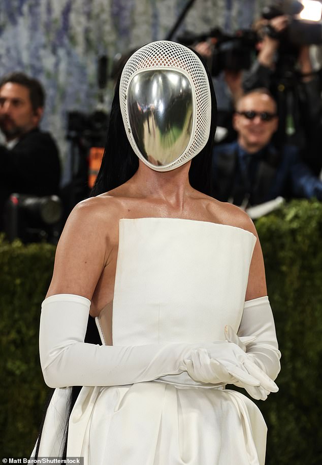 Perry hid her face at least for a little while as she sported a metal and white mesh mask on the iconic stairs of the yearly event which drew comparisons to the sport of fencing and even her controversial Blue Origin space mission from last year