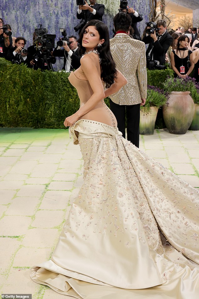 Jenner paired her gown with a set of lustrous beige heels with pointy toes that were mostly covered by her skirt, and she required two attendants behind her to hold her train aloft