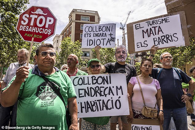 Demonstrators hold placards during a protest called by the Neighborhoods Assembly for Tourist Degrowth (ABDT), in Barcelona, Spain