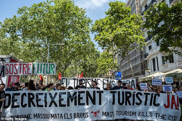 Anti-tourism protestors hold a sign that reads 'De-growth of Tourism Now'
