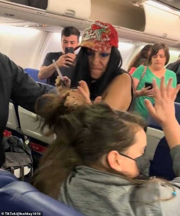 A woman repeatedly pulled another female passenger's hair, spat in her face and kicked her