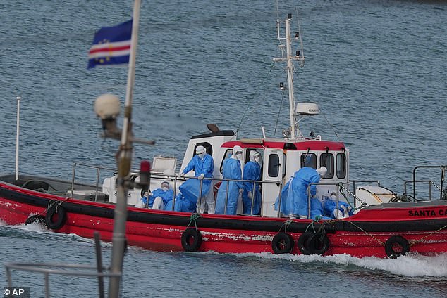 Health workers in protective gear arrive to evacuate patients from the MV Hondius cruise ship at a port in Cape Verde