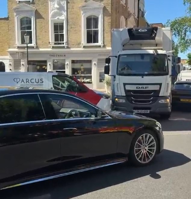 A lorry attempting to reverse all the way down Elystan Place, as cars wait to be able to pass