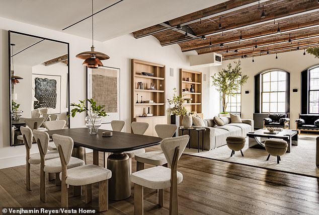 The living room area allows plenty of natural light to flood inside through large arched windows on one side