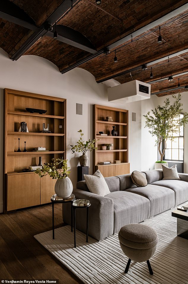 Two wooden bookshelves are secured into the wall adjacent to the row of windows