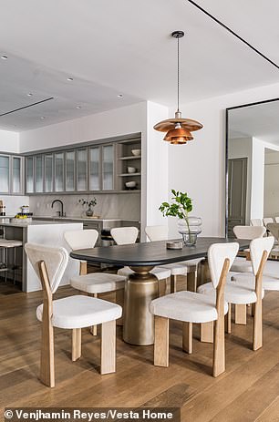 An island in the middle offers extra space for hosting and cooking while the cabinet doors are made of glass