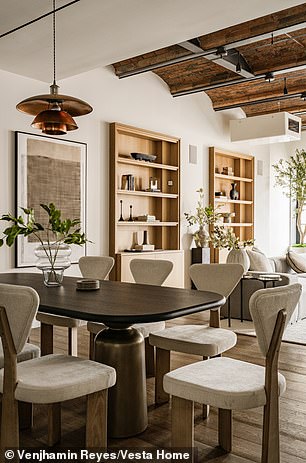 A lighting fixture seemingly made of copper material hangs over the dining room table for a unique addition to the space