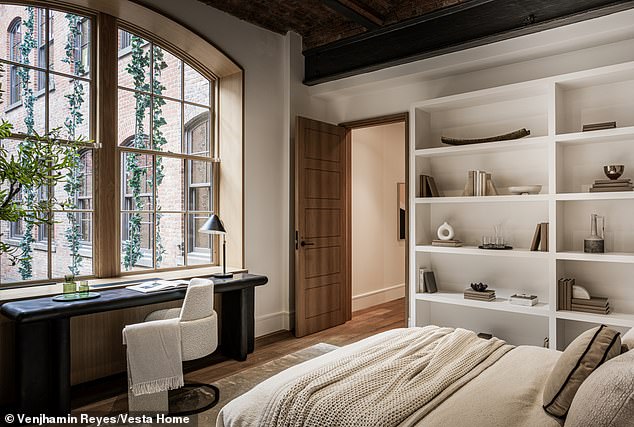 Another bedroom looks out at the building and additionally contains  built-in bookshelves and space for a desk