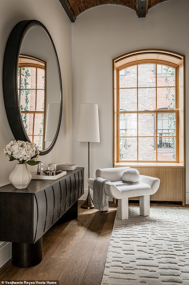 One corner of a room has another arched window to brighten the space