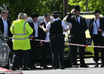 Residents at a cordoned off area following the stabbing of two Jewish people in Golders Green, London