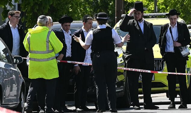 Residents at a cordoned off area following the stabbing of two Jewish people in Golders Green, London