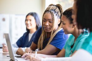 Nursing students sharing a laptop