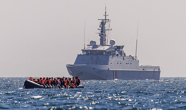 A French Warship escorts an inflatable 'small boat' carrying migrants across the channel towards Britain. Small boat gangs switching cross-Channel smuggling operations from France to Belgium have been hit by an unprecedented wave of arrests
