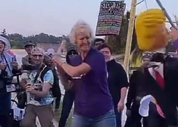 The woman's shirt bore a message about kindness and doing unto others as you would have them do unto you. Then someone put a stick in her hand and held out an effigy of President Donald Trump.