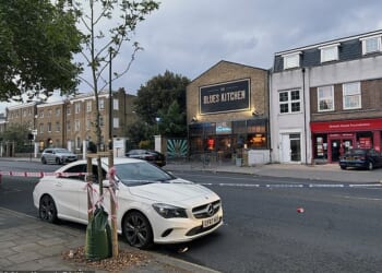 A police cordon on Acre Lane in Brixton, south London. Police are investigating the possibility that the stabbing of a man and the shooting of four people in the same area of south London are linked