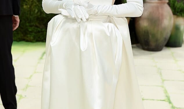Here comes the AI bride? Katy Perry completely covered her face in a robot-esque silver mask, pairing it with a strapless, white silky gown with an exaggerated square neckline. She finished off the look with a pair of white satin opera gloves