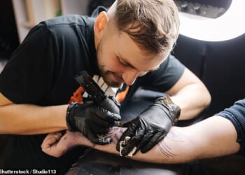Ministers have been urged to clamp down on a scheme that gives benefits claimants taxpayer-funded laptops and even tattoo equipment when they secure new jobs. PIctured: A tattooist at work (file image)