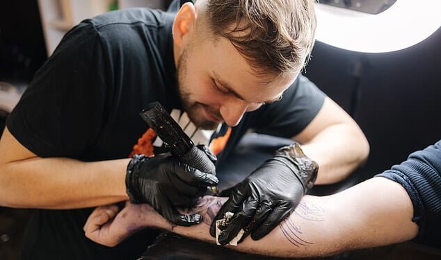 Ministers have been urged to clamp down on a scheme that gives benefits claimants taxpayer-funded laptops and even tattoo equipment when they secure new jobs. PIctured: A tattooist at work (file image)