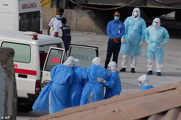 Health workers in protective gear evacuate patients from the MV Hondius cruise ship into an ambulance at a port in Praia, Cape Verde