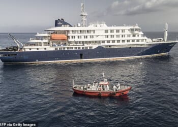 An ambulance boat carrying crew members wearing hazmat suits as they approach MV Hondius, while stationary off the port of Praia, the capital of Cape Verde, on May 5, 2026