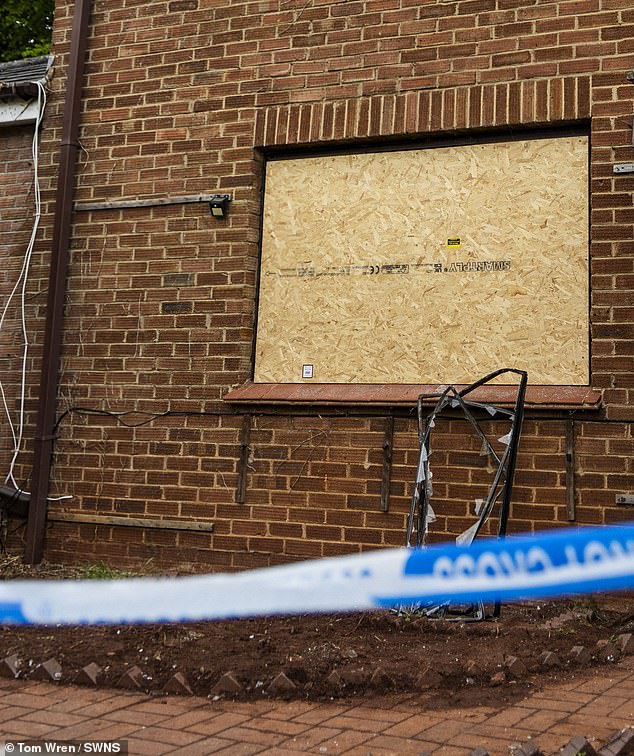 The twisted frame of a smashed window is seen propped up against the wall of the home -- May 5, 2026