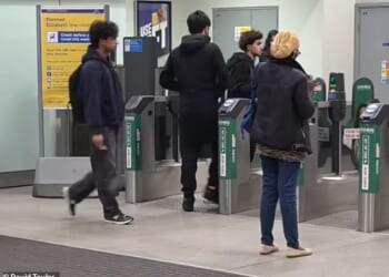 The two men in the centre were among those seen pushing through the barriers at Romford station in East London yesterday. The man on the left correctly tapped in moments later