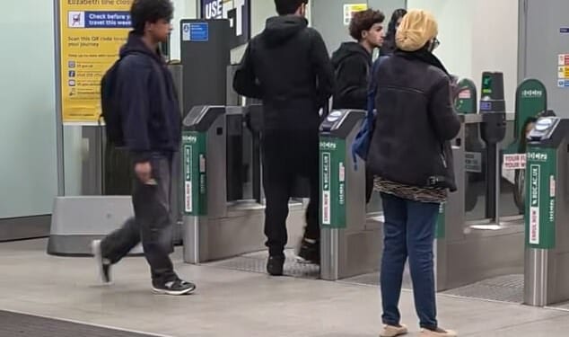 The two men in the centre were among those seen pushing through the barriers at Romford station in East London yesterday. The man on the left correctly tapped in moments later